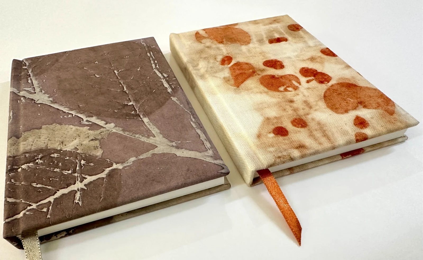Two journals with leaf and botanical patterns and ribbon markers