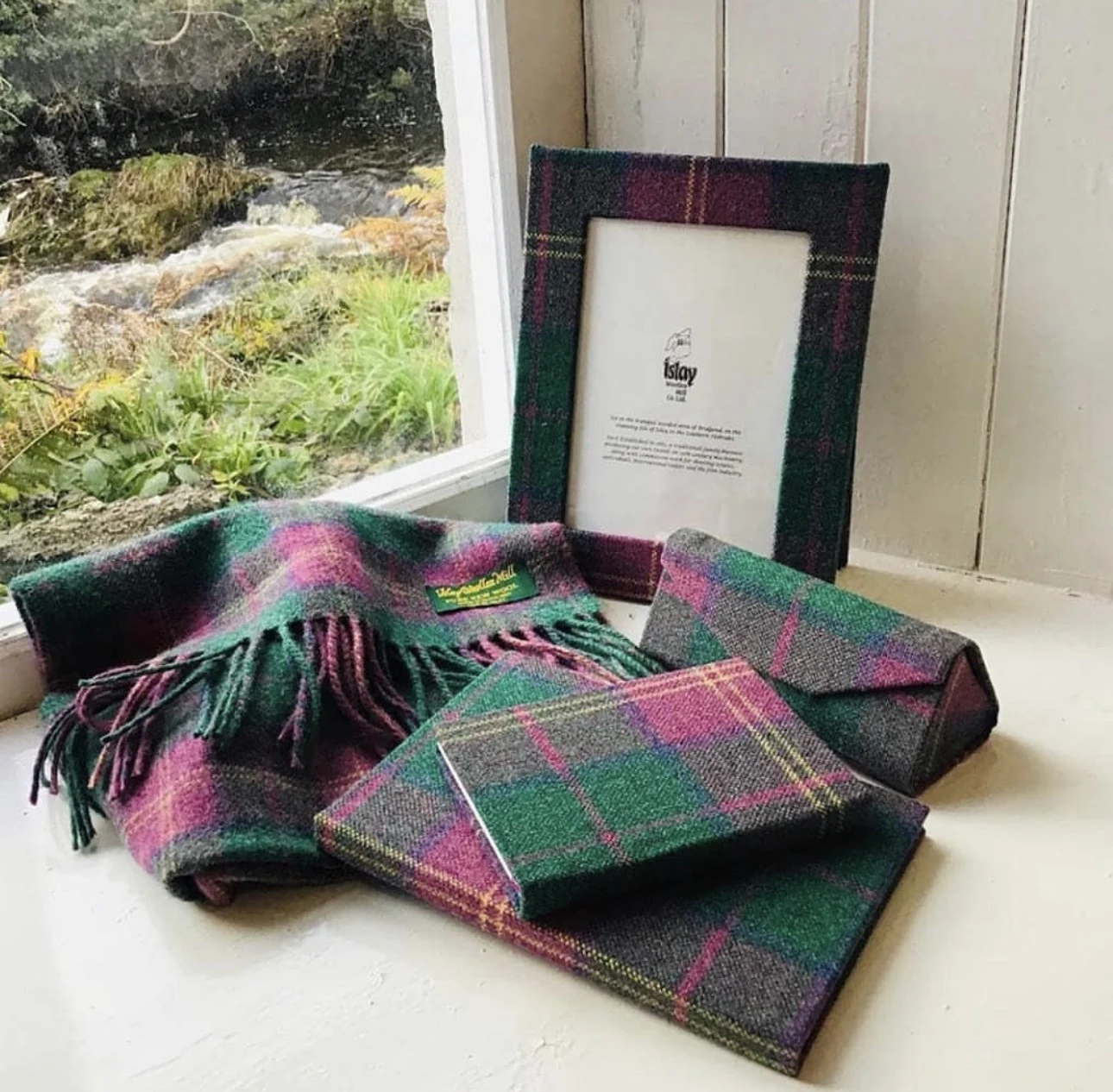Coordinated tartan-covered journals and a photo frame beside matching fabric