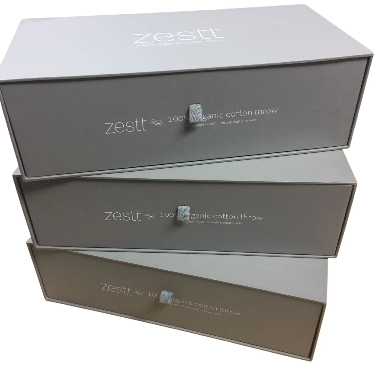 Stack of grey drawer gift boxes with ribbon pulls and white branding