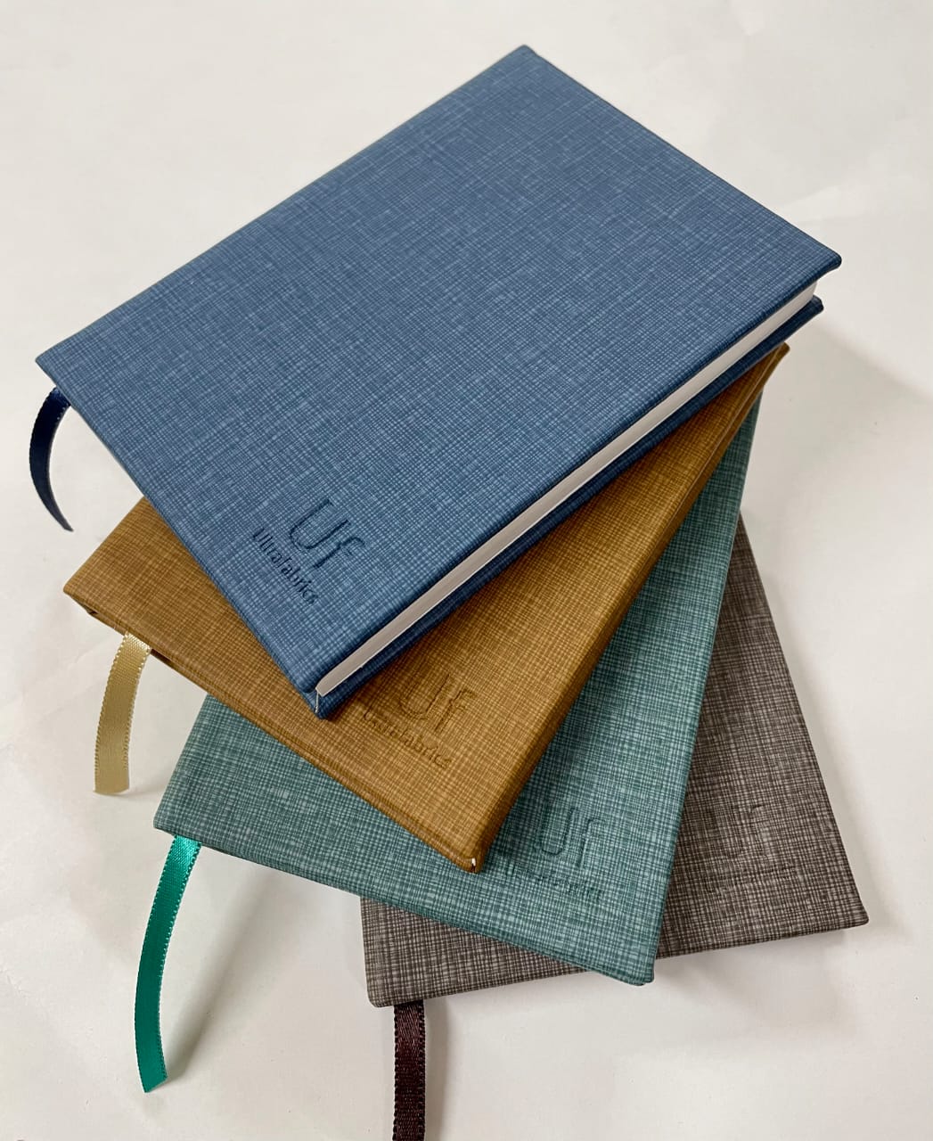 Blue, mustard, green and brown fabric journals with ribbon markers