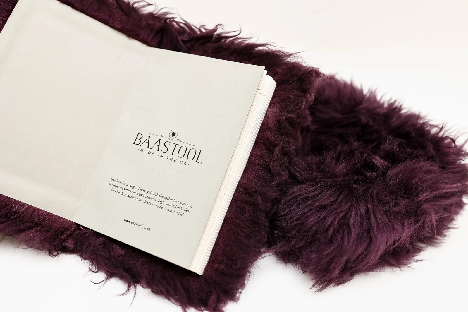 Open journal with a deep burgundy plush cover and a custom printed Baa Stool endpaper