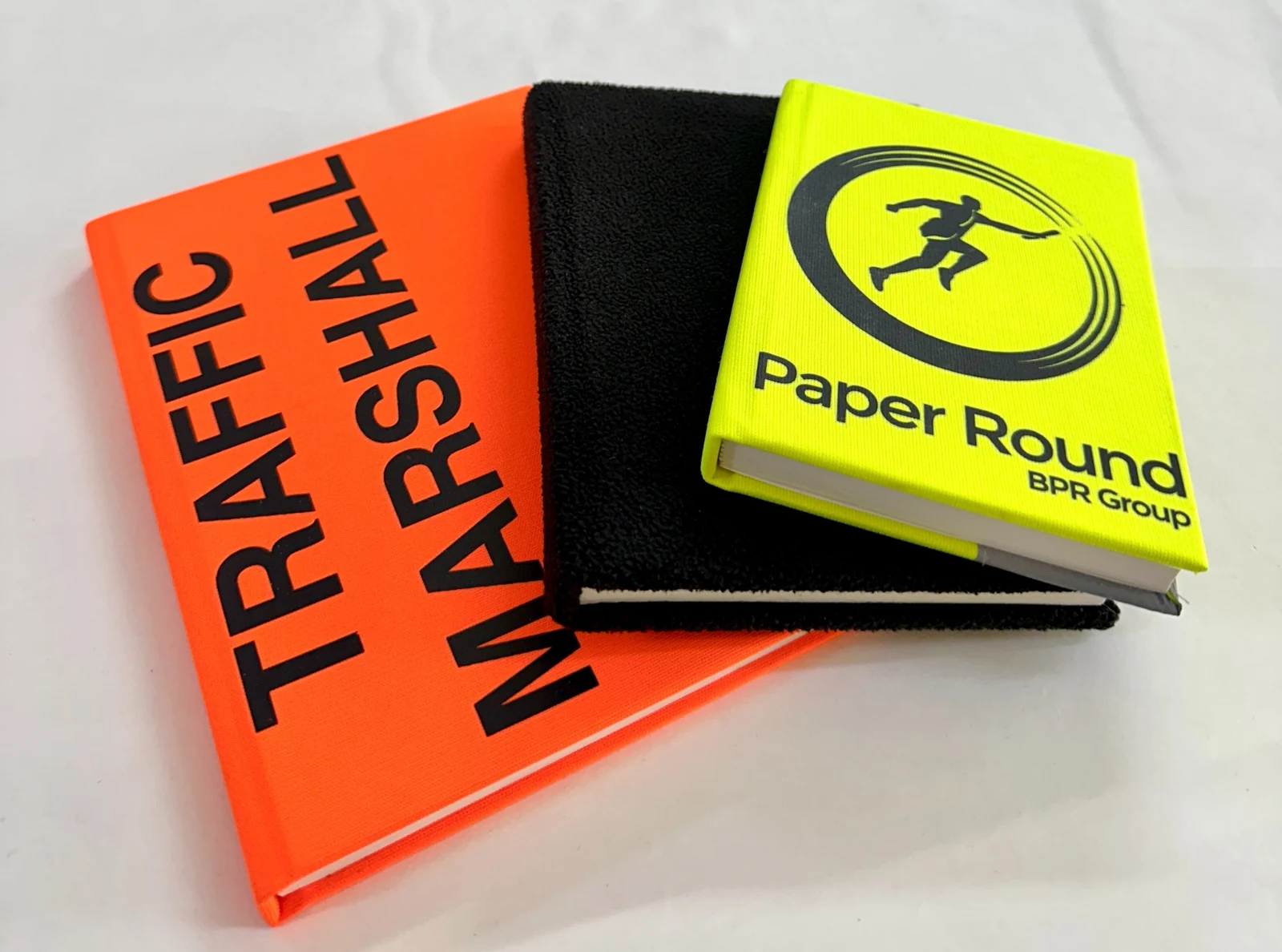 Orange, black and yellow branded workplace notebooks